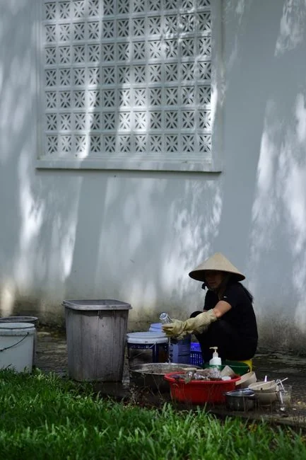 A man cleaning a glass door indoors using a spray bottle and cloth.